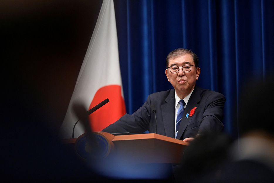 石破茂首相は２６日、政府と経済界、労働団体のトップが意見交換する「政労使会議」のあいさつで、来年の春闘について「労働者の賃金水準を引き上げるベースアップを念頭に３３年ぶりの高水準の賃上げとなった今年の勢いで大幅な賃上げの協力をお願いする」と述べた。写真は官邸で会見する石破首相。１０月撮影。（2024年 ロイター/David Mareuil/Pool via REUTERS）