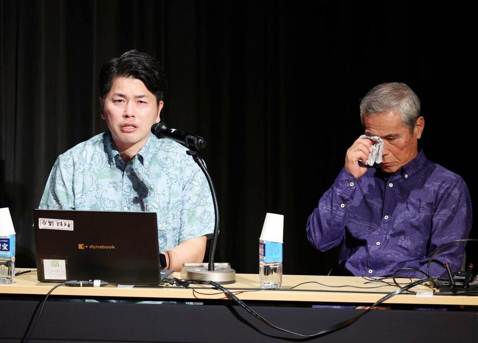 真菜さんと莉子ちゃんの写真や映像を見せながら講演し、涙ぐむ松永拓也さん（左）と上原義教さん＝25日午後、西原町のさわふじ未来ホール（小川昌宏撮影）