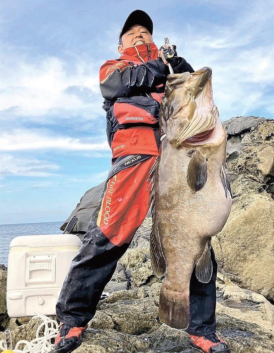 釣り上げた大物のクエを持ち上げる渡部幸太郎さん＝１６日午前、島根県海士町、二股島