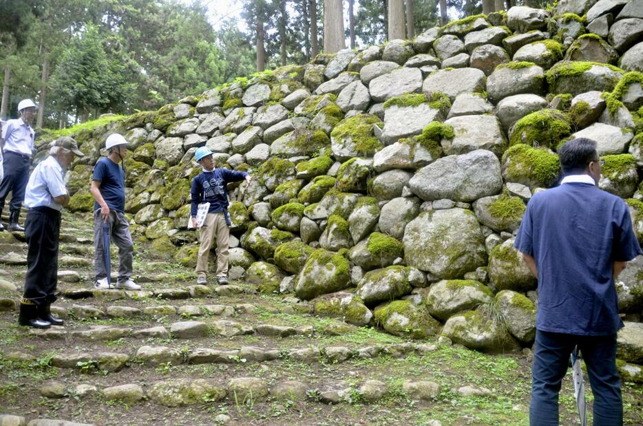 七尾城跡の地震被害について担当者から説明を聞く専門家ら＝2024年8月、石川県七尾市