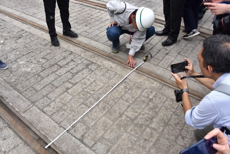 白鳥橋で出土した都電遺構の一般公開では、都職員がメジャーを使って都電独特の1372ミリメートル軌間を示した（写真撮影：小川裕夫）