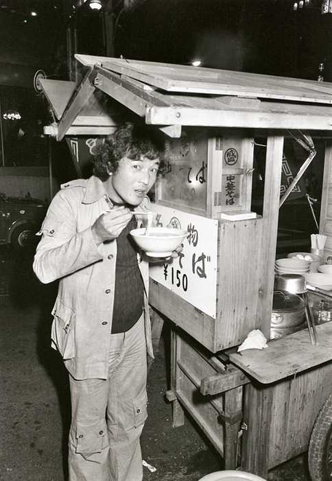 中華そばの屋台で立ち食いをする愛川欽也さん（写真：Kodansha/アフロ）