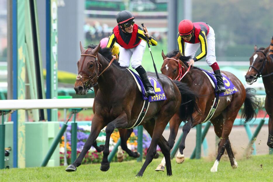 ゴールの瞬間、左手をあげるデムーロ騎手（右は2着のリアルスティール）＝2015年4月19日（写真：中原義史/アフロ）