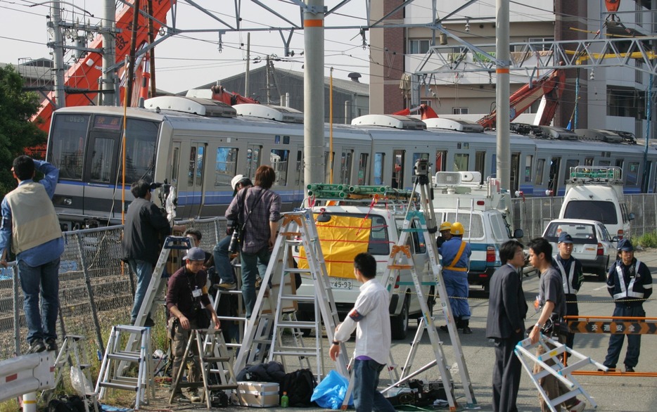 事故車両を見守る報道陣＝2005年4月28日（写真：ロイター/アフロ）