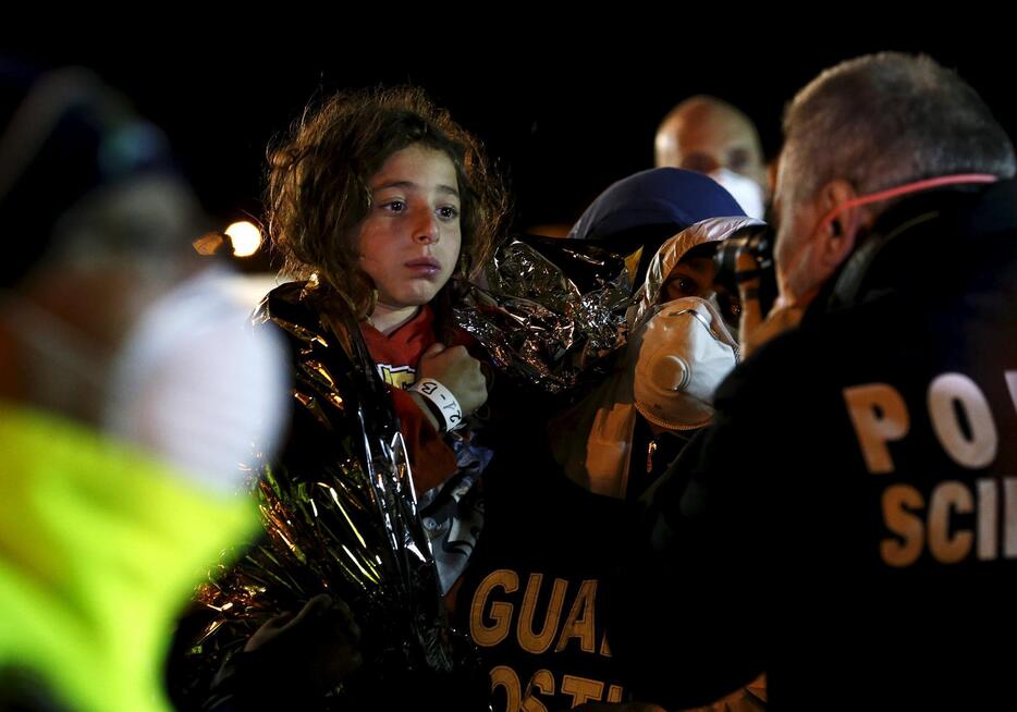 移民の子供を撮影するイタリア警察＝2015年4月19日（写真：ロイター/アフロ）