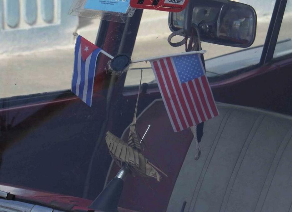 [写真]キューバと米国の国旗が飾られたタクシー