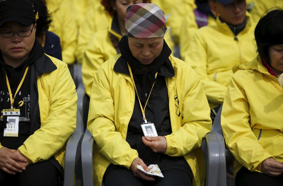 港での式典で息子の写真を見る母親＝2015年4月15日（写真：ロイター/アフロ）