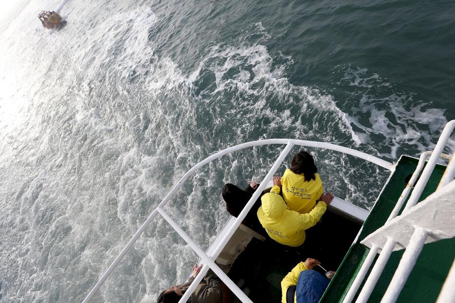 海に花を手向ける遺族ら＝2015年4月15日（写真：代表撮影/ロイター/アフロ）