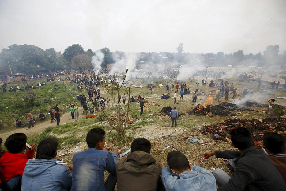 地震の犠牲者の遺体を火葬する人々＝2015年4月26日（写真：ロイター/アフロ）