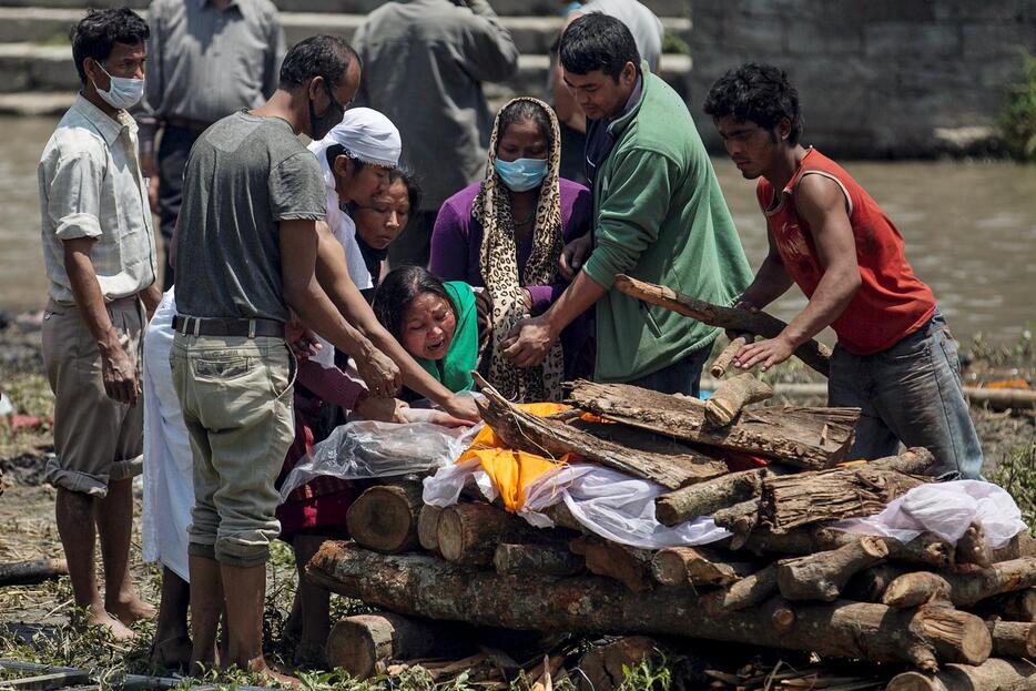 地震で死亡した父親を見送る女性ら＝2015年4月27日（写真：ロイター/アフロ）