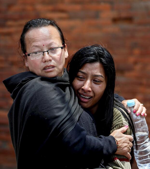 親族の遺体を前に泣き悲しむ女性＝2015年4月27日（写真：ロイター/アフロ）