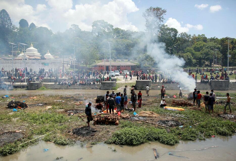 川沿いで火葬されるネパール地震の犠牲者＝2015年4月27日（写真：ロイター/アフロ）