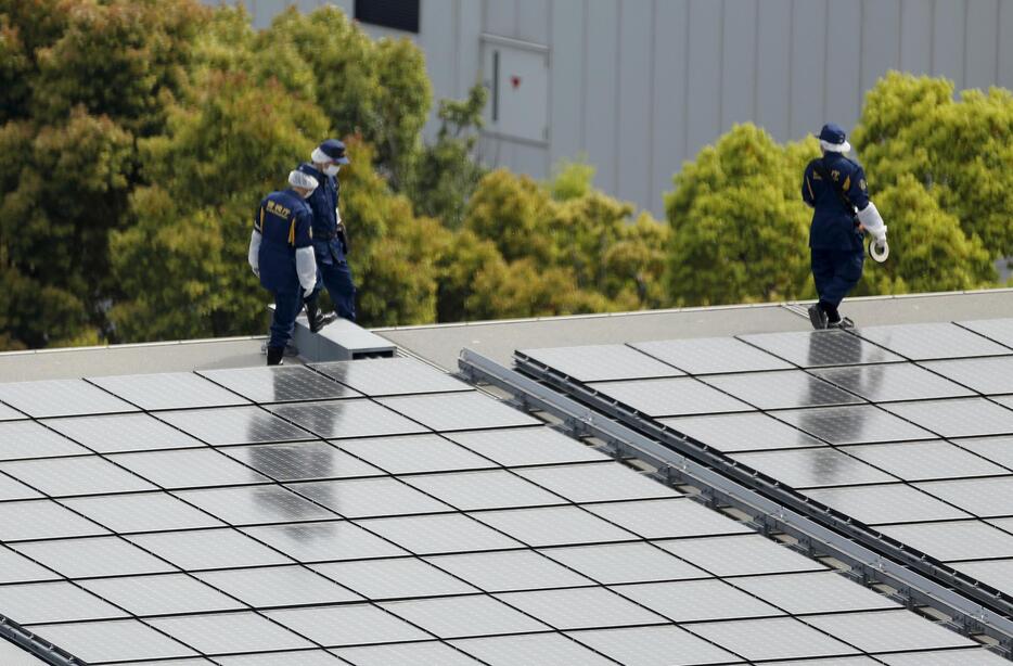 屋根を点検する捜査員＝2015年4月22日（写真：ロイター/アフロ）