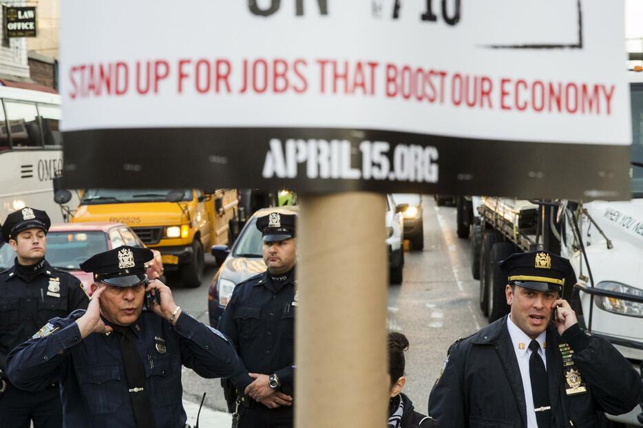 携帯電話で話す警察官＝2015年4月15日（写真：ロイター/アフロ）