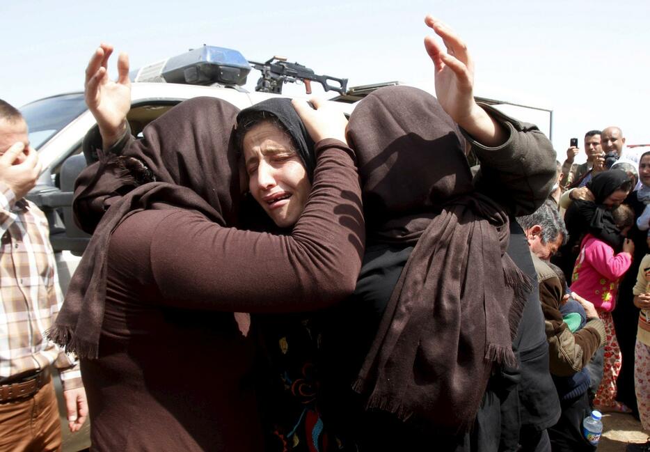 過激派組織「イスラム国」から解放され抱き合う人々（写真：ロイター/アフロ）