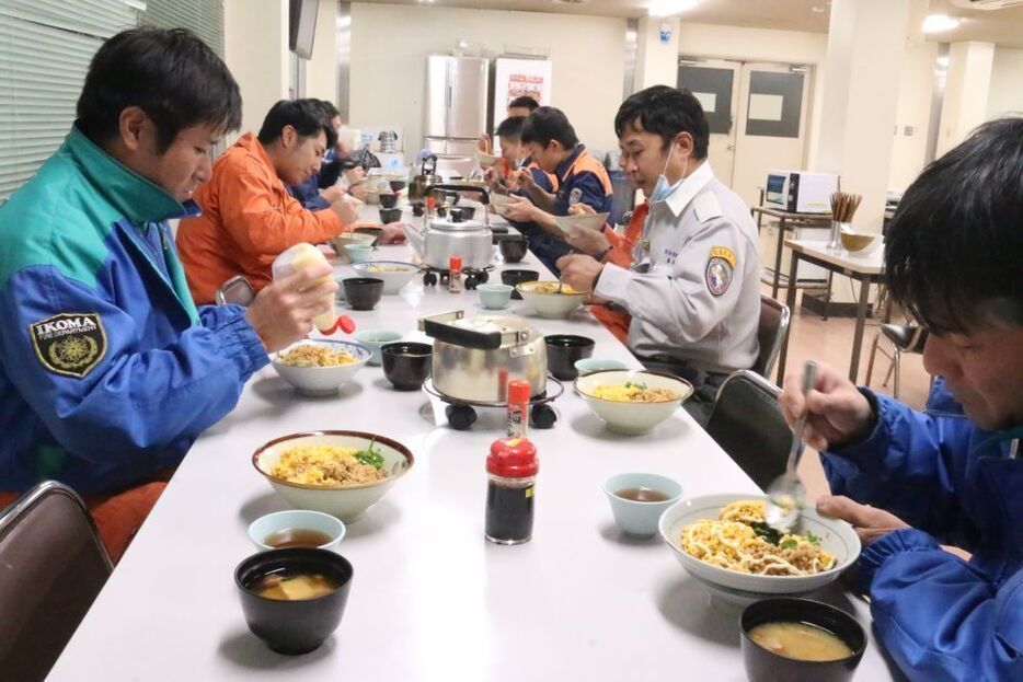 [写真]若手が作った三色丼をほおばる消防隊員たち。だが、いつ出動がかかるかわからない