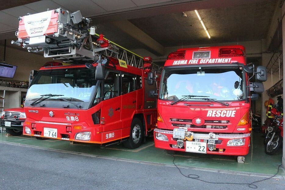 [写真]生駒市消防署のはしご車（左）と救助工作車