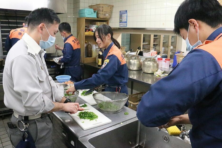 [写真]夕食（消防メシ）を作る隊員たち。隊員になってからご飯を作るようになったという人も多かった