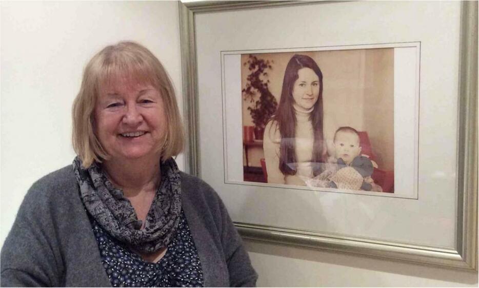 [写真]ジュリア・メインウォリングさん近影。2014年4月筆者撮影。壁に掛けられた娘さんと写っている写真は、1970年代に既婚女性として初めてロンドンの公営住宅の契約者として 裁判で認められた日に、新聞記者に撮影されたもの。