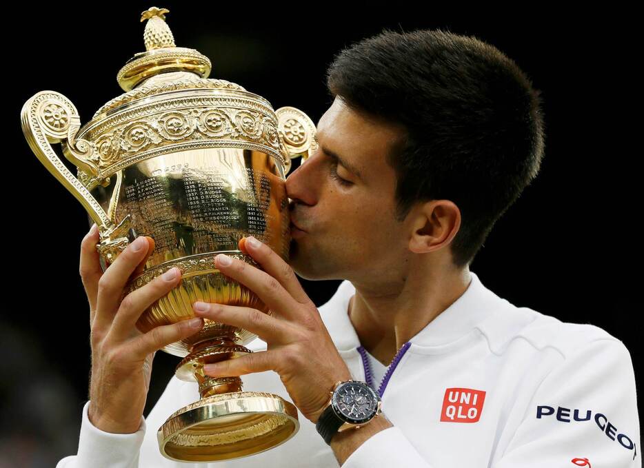 優勝トロフィーにキスをするジョコビッチ＝2015年7月12日（写真：ロイター/アフロ）