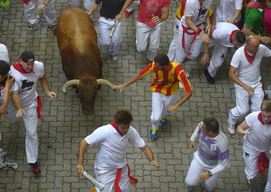 走りながら角に触れる男性＝2015年7月7日（写真：ロイター/アフロ）