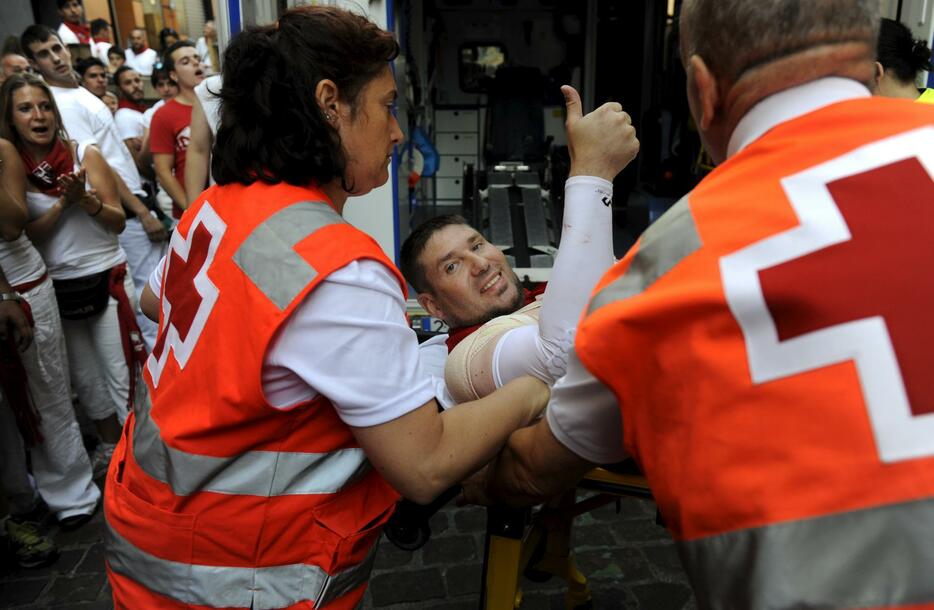 救護班に運ばれながらもガッツポーズ＝2015年7月7日（写真：ロイター/アフロ）