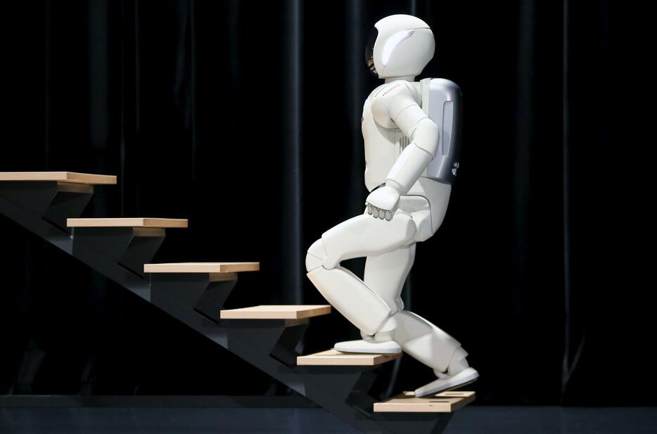 階段を登る「ASIMO」。制御技術が「歩行アシスト」に生かされた＝2014年7月16日（写真：ロイター/アフロ）