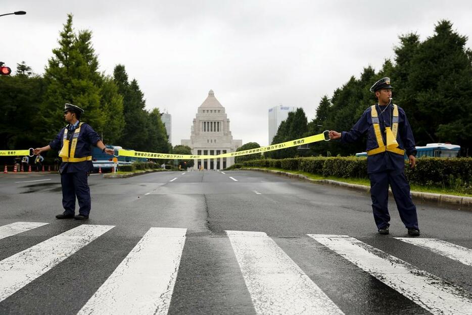 [写真]安保関連法案が衆議院を通過した7月16日、国会前で抗議デモに備え非常線を張る警察官ら（ロイター/アフロ）