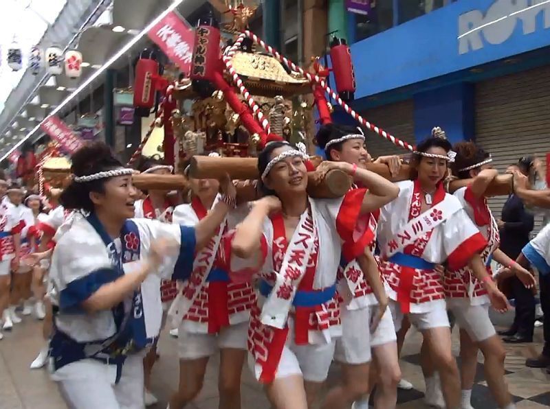 [写真]今年は歴代選抜メンバーで構成されたギャルみこし。タスキにはミス天神橋を獲得した西暦が記されていた＝23日午後12時5分ごろ、大阪市北区で