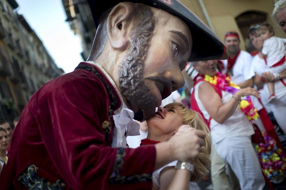 パレードに使われる人形・キリキスに捕まった女性＝2015年月7月6日（写真：ロイター/アフロ）