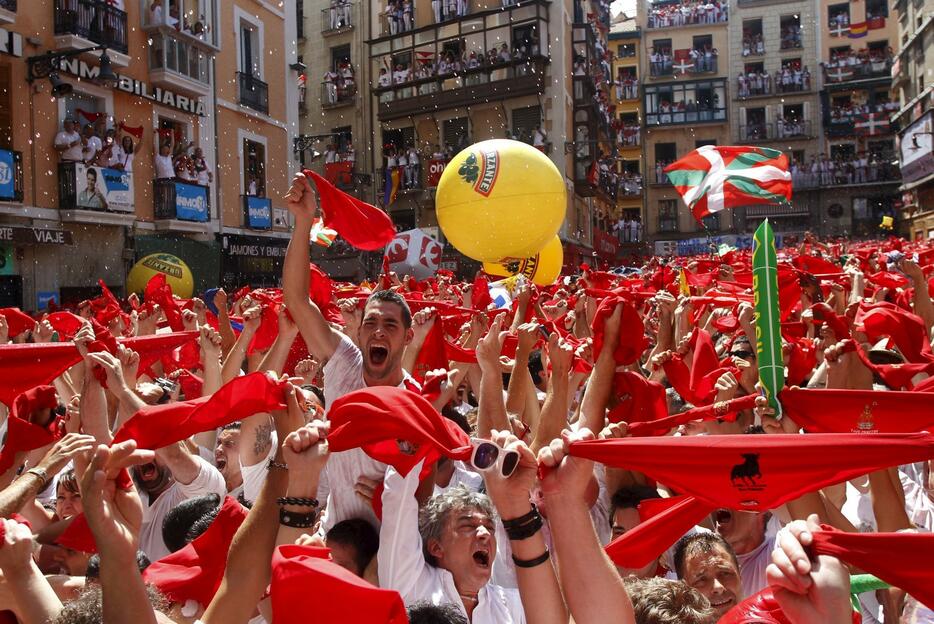赤いスカーフを掲げ開幕を祝う人々＝2015年月7月6日（写真：ロイター/アフロ）
