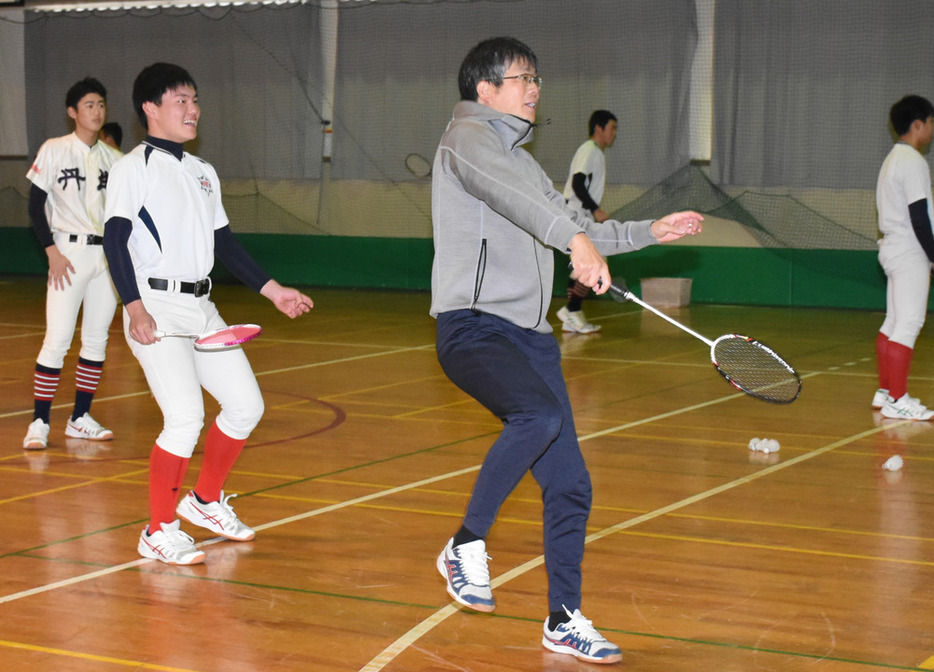 バドミントンで汗を流す丹生の来田竹竜主将（手前左）と春木竜一監督＝福井県越前町内郡の同校で２０２１年１２月、大原翔撮影