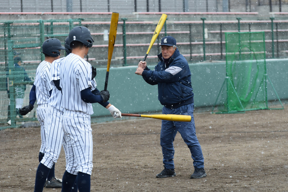 楠城監督（右）に打撃指導を受ける九国大付の選手たち