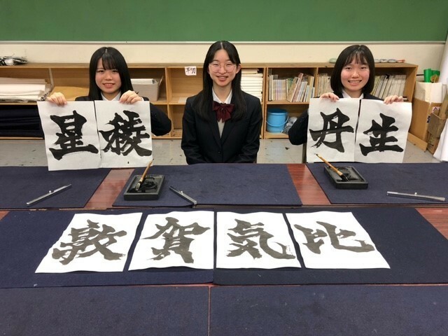 出場校の校名を揮毫した（左から）阿部奏会さん、信田香乃さん、佐藤夕海さん＝新潟高校提供