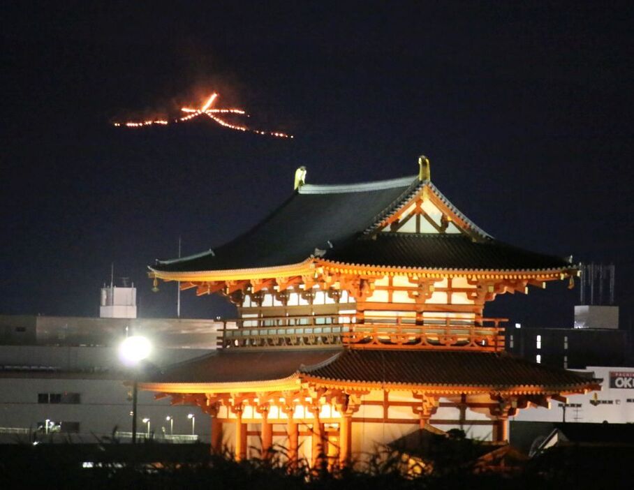 [写真]戦没者慰霊と世界平和祈る炎の奈良「大文字送り火」。手前に見えるのは朱雀門=15日午後8時15分ごろ、奈良県奈良市の平城宮跡から高円山方面を望む（撮影：柳曽文隆）