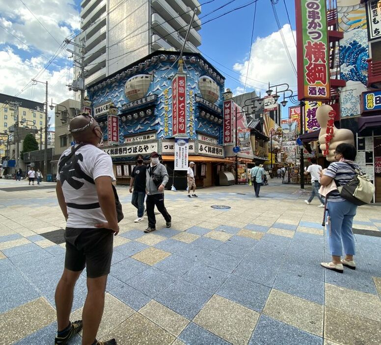 ふぐ看板の下を拠点とする人力車の俥夫（しゃふ）も残念そうな表情でづぼらや本店を眺める