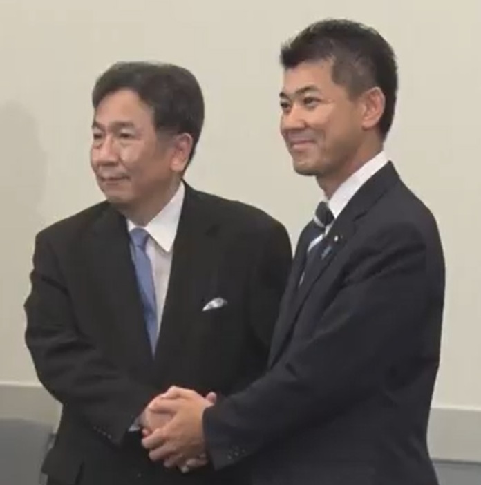 共同会見後に握手する枝野氏（左）と泉氏（右）