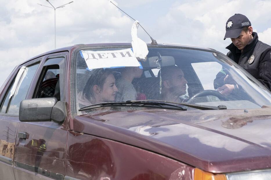 ロシア支配地域からザポリージャに到着した家族。車にはロシア語で「子ども」と書かれた紙が貼られ白い布が巻かれていた。2022年5月2日撮影