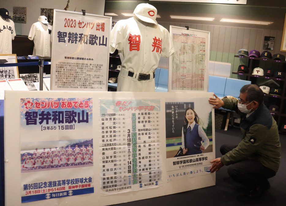 展示コーナーにポスター（右下）を掲示する江川館長＝和歌山市で２０２３年２月２２日午後１時１分、大塚愛恵撮影