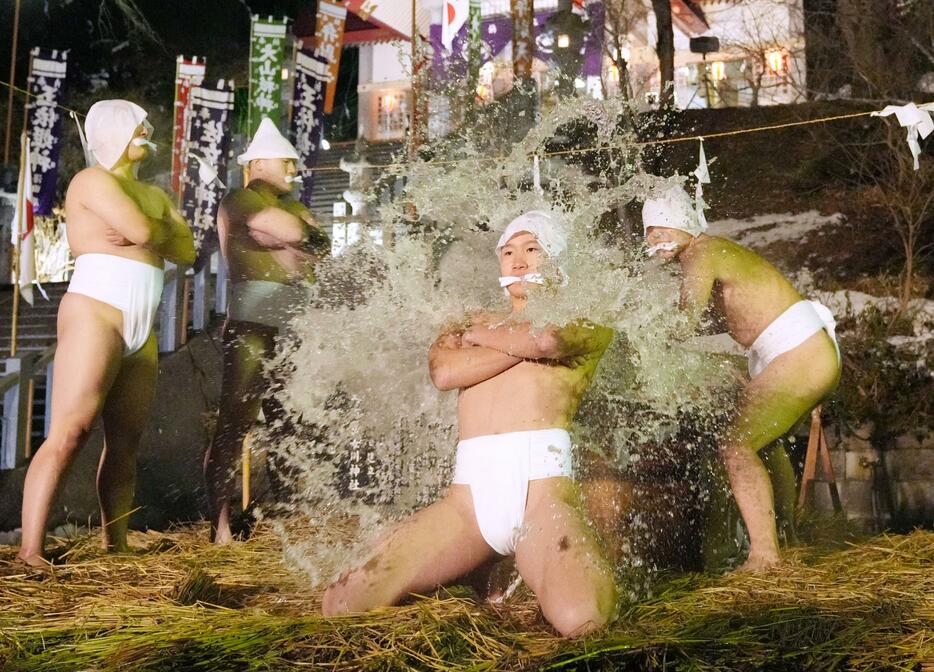 神事「寒中みそぎ」で冷水を浴び、身を清める下帯姿の「行修者」＝13日夜、北海道木古内町の佐女川神社