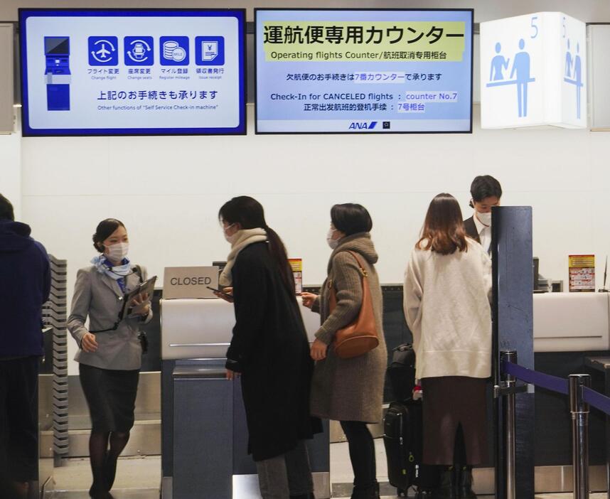 新千歳空港で航空会社のカウンターに並ぶ人たち＝4日午前