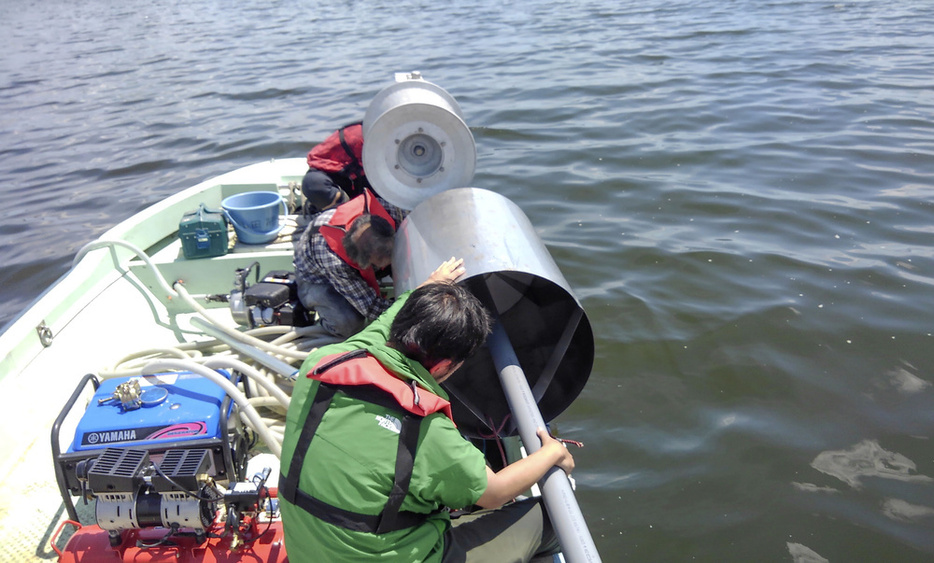 島根県の宍道湖で湖底の堆積物を採取する研究チームのメンバーら＝2021年7月（島根大の仲村康秀助教提供）