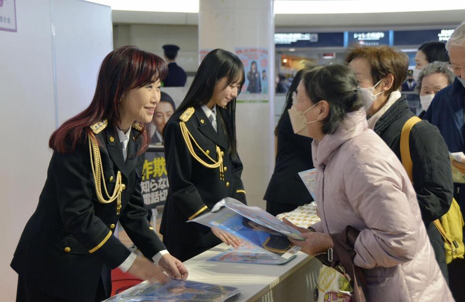 イベント参加者にチラシを配布する伍代夏子さん（左端）ら＝26日午後、広島市