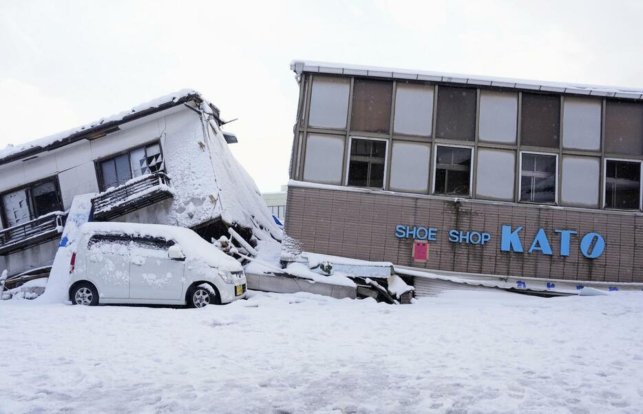 倒壊した建物に雪が積もった石川県穴水町の被災地＝8日午前9時15分