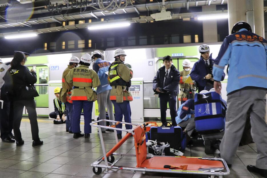 JR秋葉原駅の山手線ホームで、刃物で切り付けられたとみられる人を搬送する消防隊員ら（右）＝3日午後11時37分