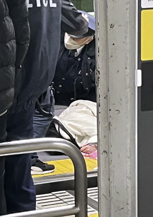 電車内で取り押さえられた容疑者とみられる女（中央）＝3日夜、JR秋葉原駅（目撃者提供）