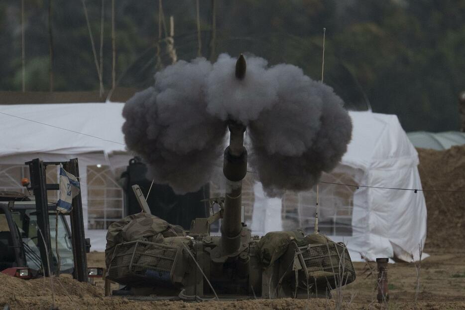 14日、イスラエル南部からパレスチナ自治区ガザに向けて攻撃するイスラエル軍砲兵部隊（AP＝共同）