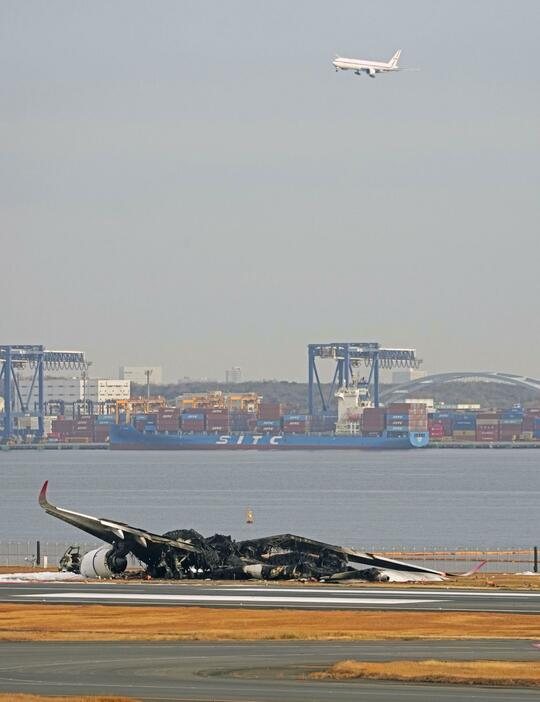 羽田空港の滑走路で炎上し、焼け焦げた日航機＝3日午前8時14分