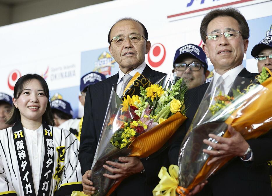 那覇空港に到着し、歓迎セレモニーで花束を手に記念撮影する阪神・岡田監督（中央）＝31日