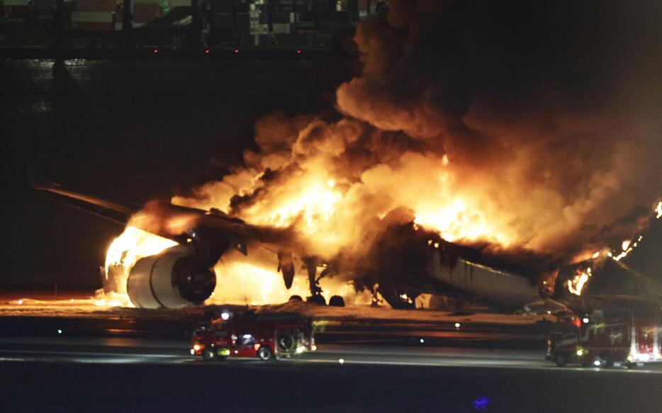 羽田空港の滑走路で炎上する日航機＝2日